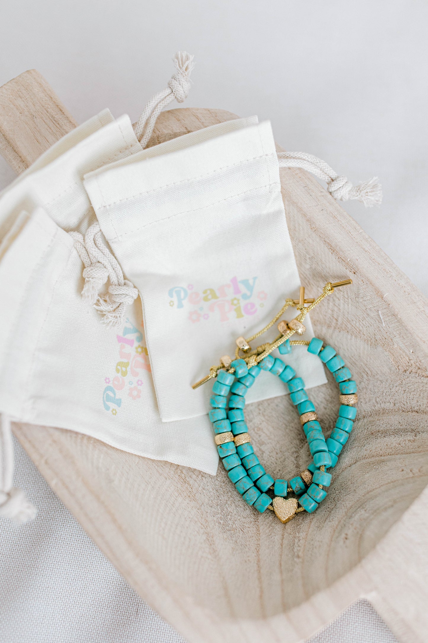 The perfect addition to your jewelry collection! This beautiful blue bracelet is made with forte gemstones and 18k gold filled stardust spacer beads that are strung on lurex cord with an adjustable sliding knot including a beautiful gold heart bead as a finishing touch. The blue forte beads have a gorgeous turquoise look to them for that lovely pop of color. This bracelet can be made with or without the heart bead.