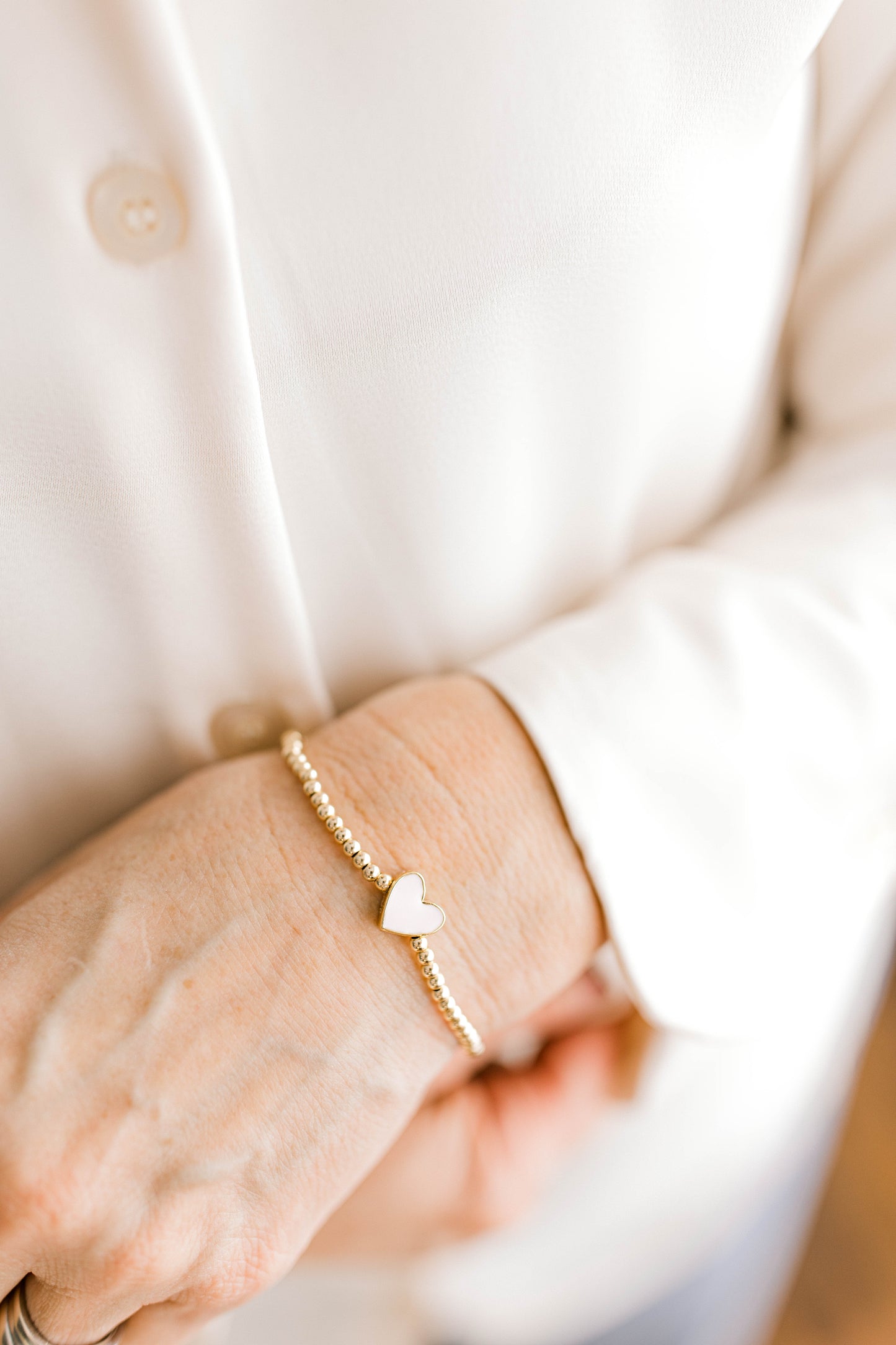A simple and cute heart bracelet that goes with any outfit, day or night! 3mm 14K gold filled beads with a pink or white heart spacer bead!