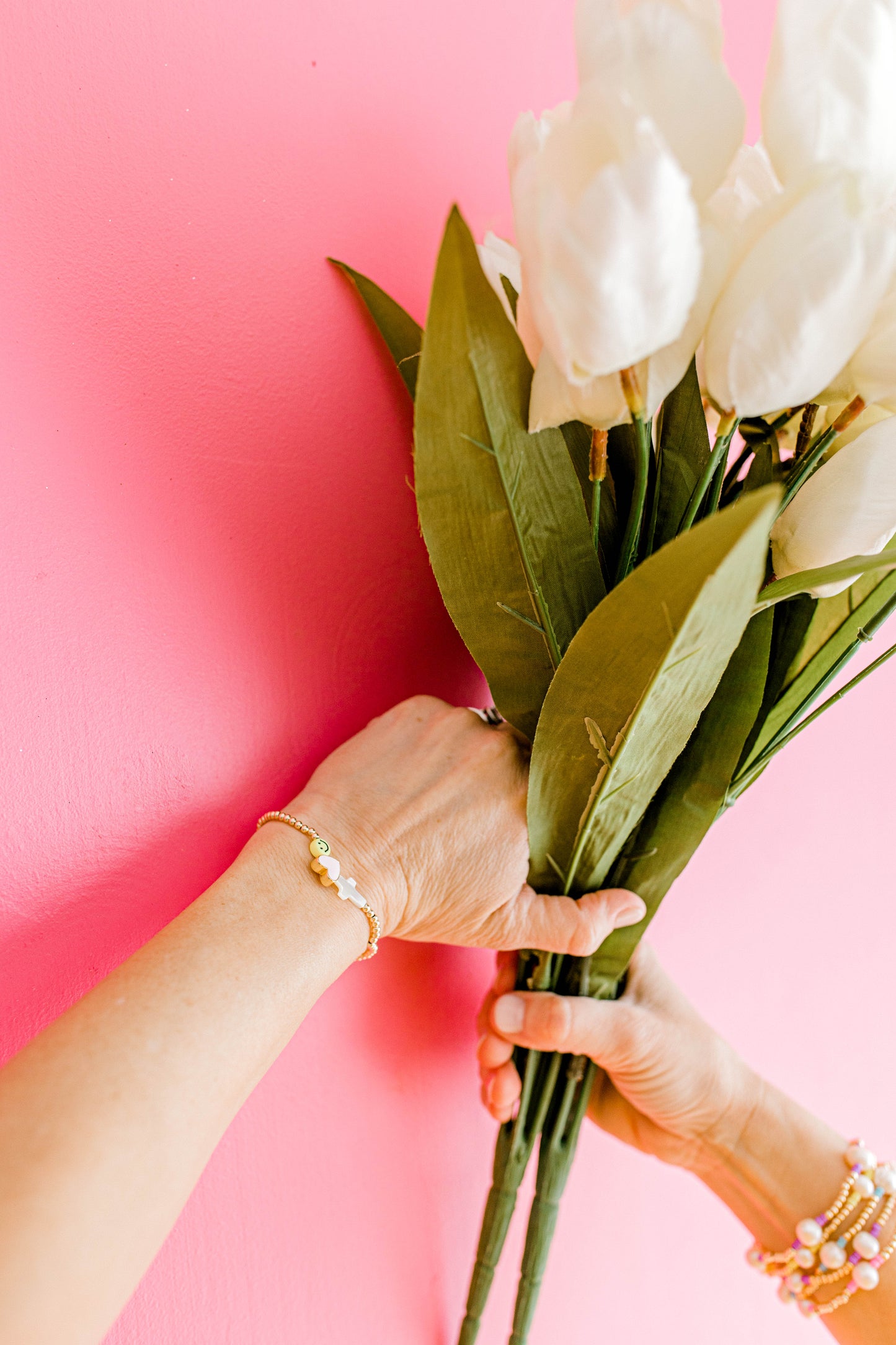John 16:27 says, "for the Father himself loves you, because you have loved me and have believed that I came from God." This beautiful bracelet includes the Mother of Pearl cross, a pink enamel heart, and a yellow smiley face with 3mm gold beads.