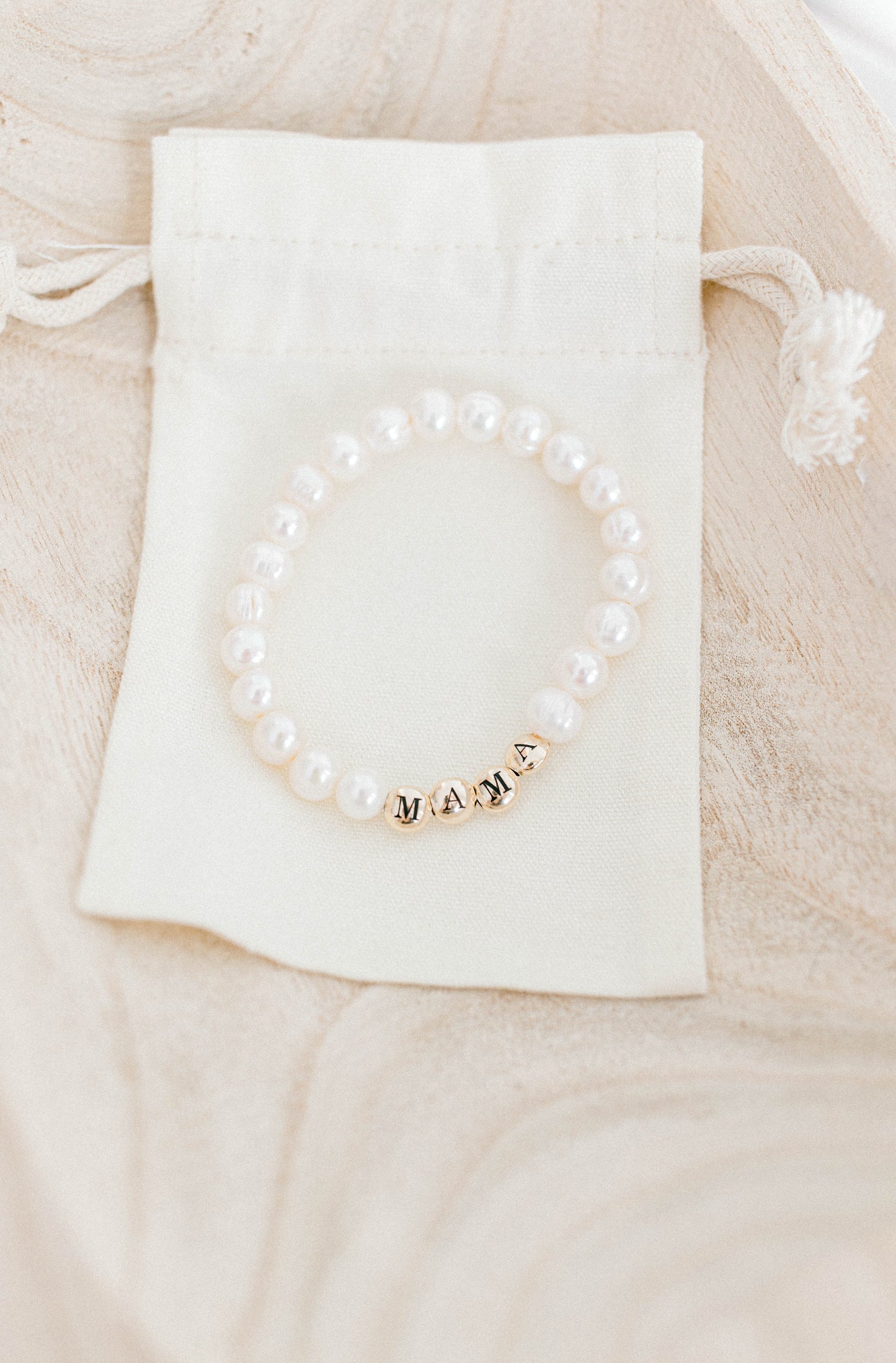 The perfect bracelet for all the mamas out there! This freshwater pearl bracelet can be made with gold letter beads or white letter beads.