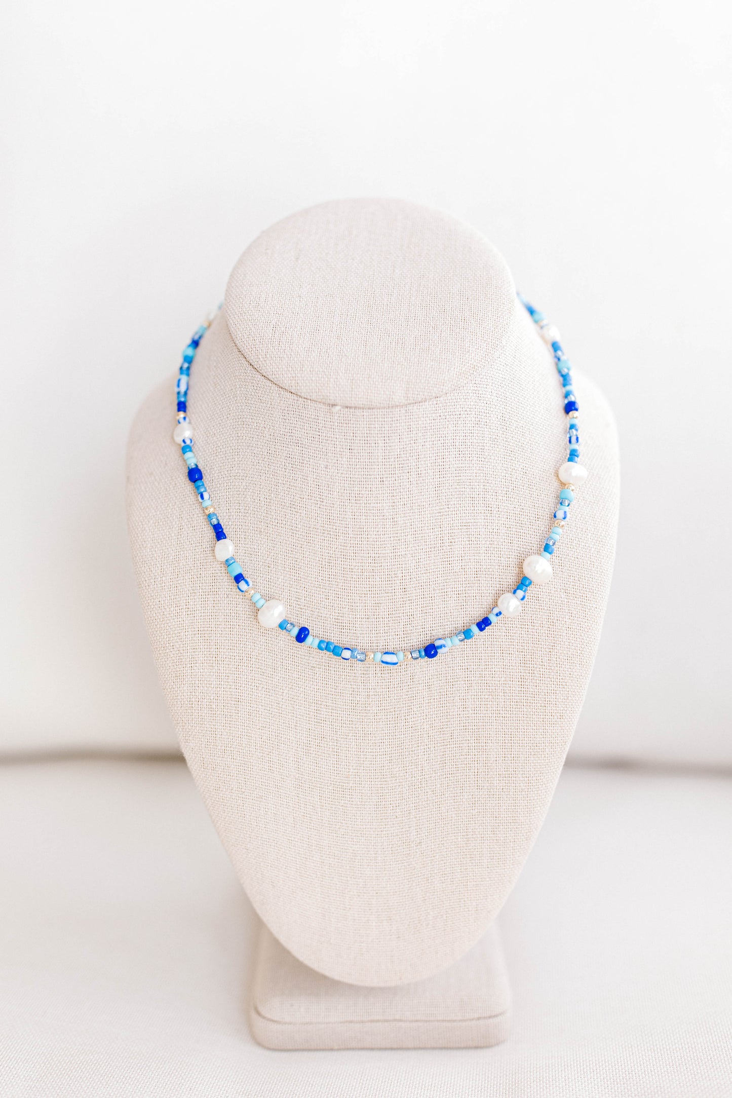 The perfect summer necklace is here and ready for the party! This beautiful necklace is made using multi color shades of blue seed beads, gold filled beads, and freshwater pearls creating a playful pattern for this necklace. This necklace is 15 inches with a 2 inch extender with a gold filled clasp and jump rings.