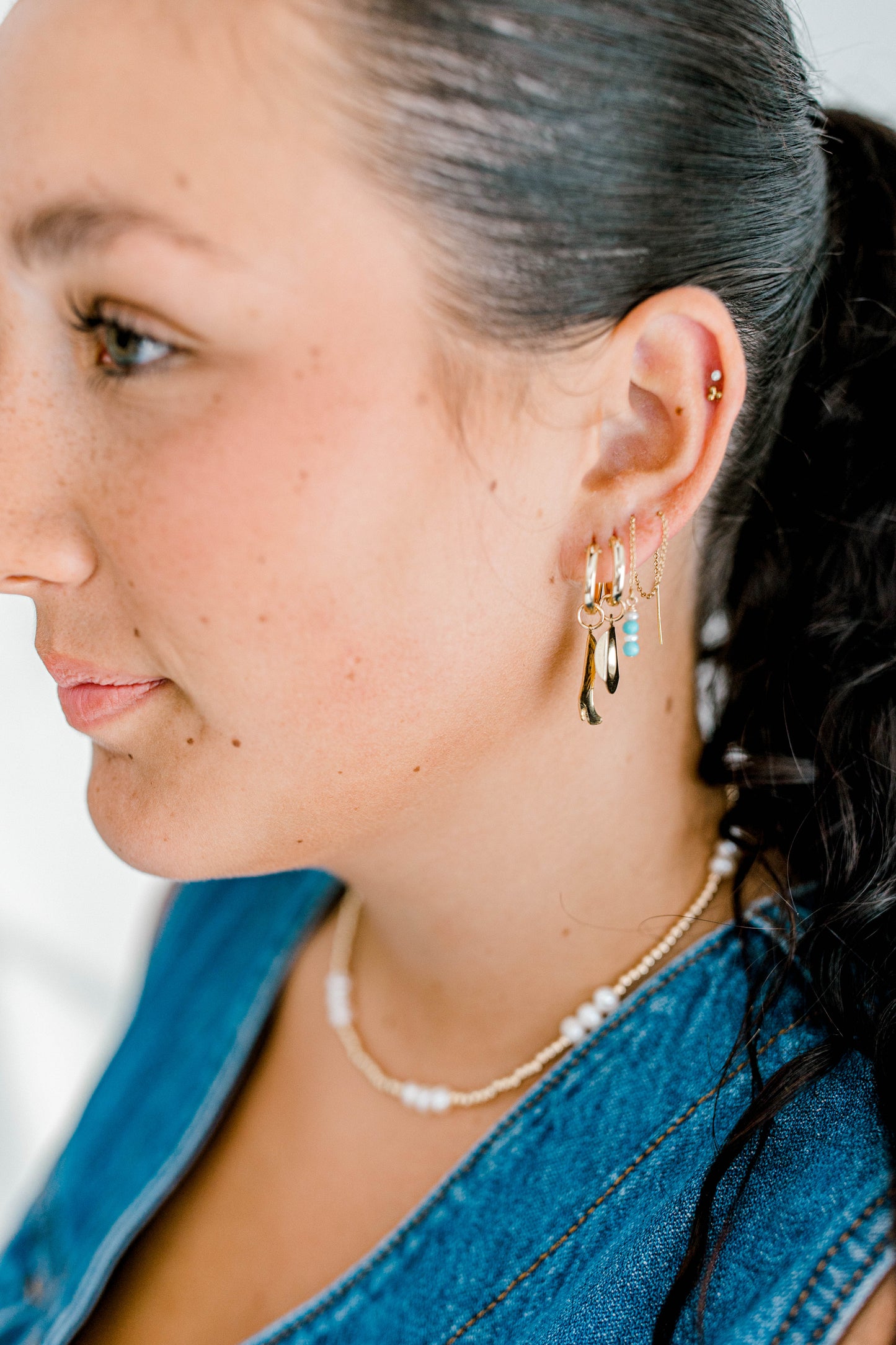 14k gold filled threader earrings that are handmade with pearl and turquoise accents at the bottom of this earring. There are four beads at the bottom of the threader earring where pearl and turquoise beads are alternately stacked starting with a pearl bead. This threader has a very dainty chain that can go through your ears with ease. Can buy singles or pairs of each design.