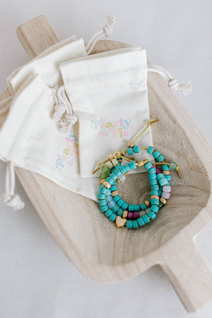 The perfect addition to your jewelry collection! This beautiful blue bracelet is made with forte gemstones and 18k gold filled stardust spacer beads that are strung on lurex cord with an adjustable sliding knot including a beautiful gold heart bead as a finishing touch. The blue forte beads have a gorgeous turquoise look to them for that lovely pop of blue.  This bracelet can be made with or without the heart bead.