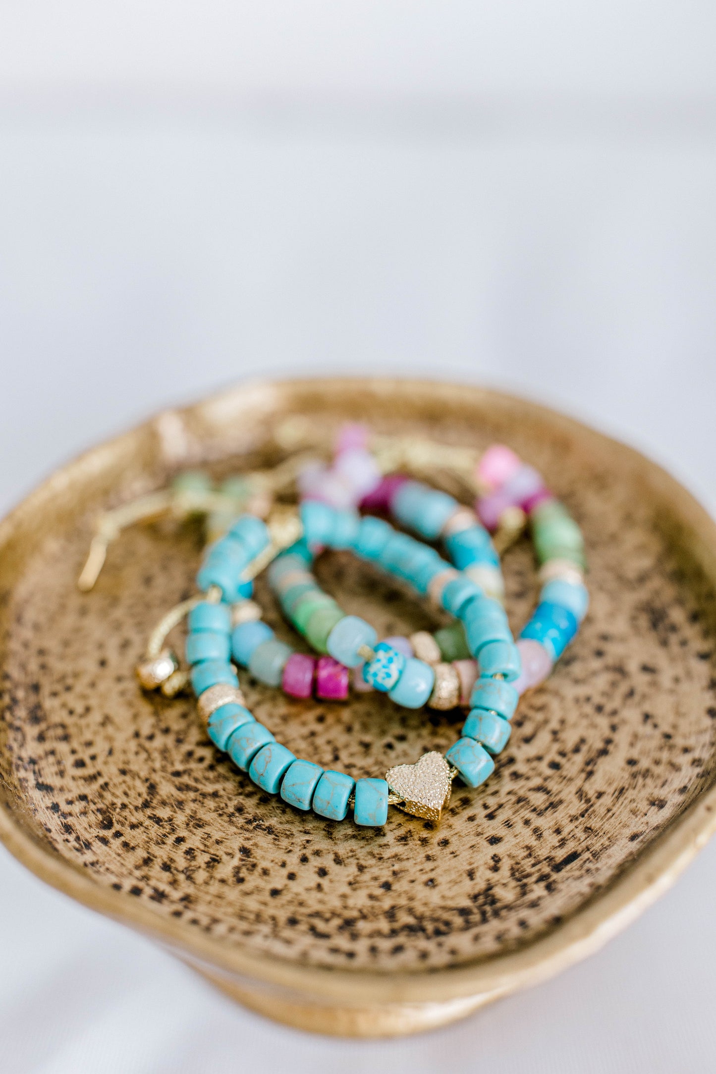 The perfect addition to your jewelry collection! This beautiful blue bracelet is made with forte gemstones and 18k gold filled stardust spacer beads that are strung on lurex cord with an adjustable sliding knot including a beautiful gold heart bead as a finishing touch. The blue forte beads have a gorgeous turquoise look to them for that lovely pop of color.  This bracelet can be made with or without the heart bead.