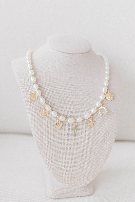 Custom charm necklace made with pearl beads, 14k gold filled spacer beads, and a collection of charms representing the He Left the 99 collection. 