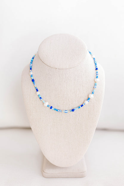 The perfect summer necklace is here and ready for the party! This beautiful necklace is made using multi color shades of blue seed beads, gold filled beads, and freshwater pearls creating a playful pattern for this necklace. This necklace is 15 inches with a 2 inch extender with a gold filled clasp and jump rings.