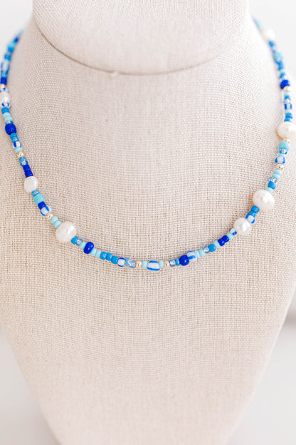 The perfect summer necklace is here and ready for the party! This beautiful necklace is made using multi color shades of blue seed beads, gold filled beads, and freshwater pearls creating a playful pattern for this necklace. This necklace is 15 inches with a 2 inch extender with a gold filled clasp and jump rings.