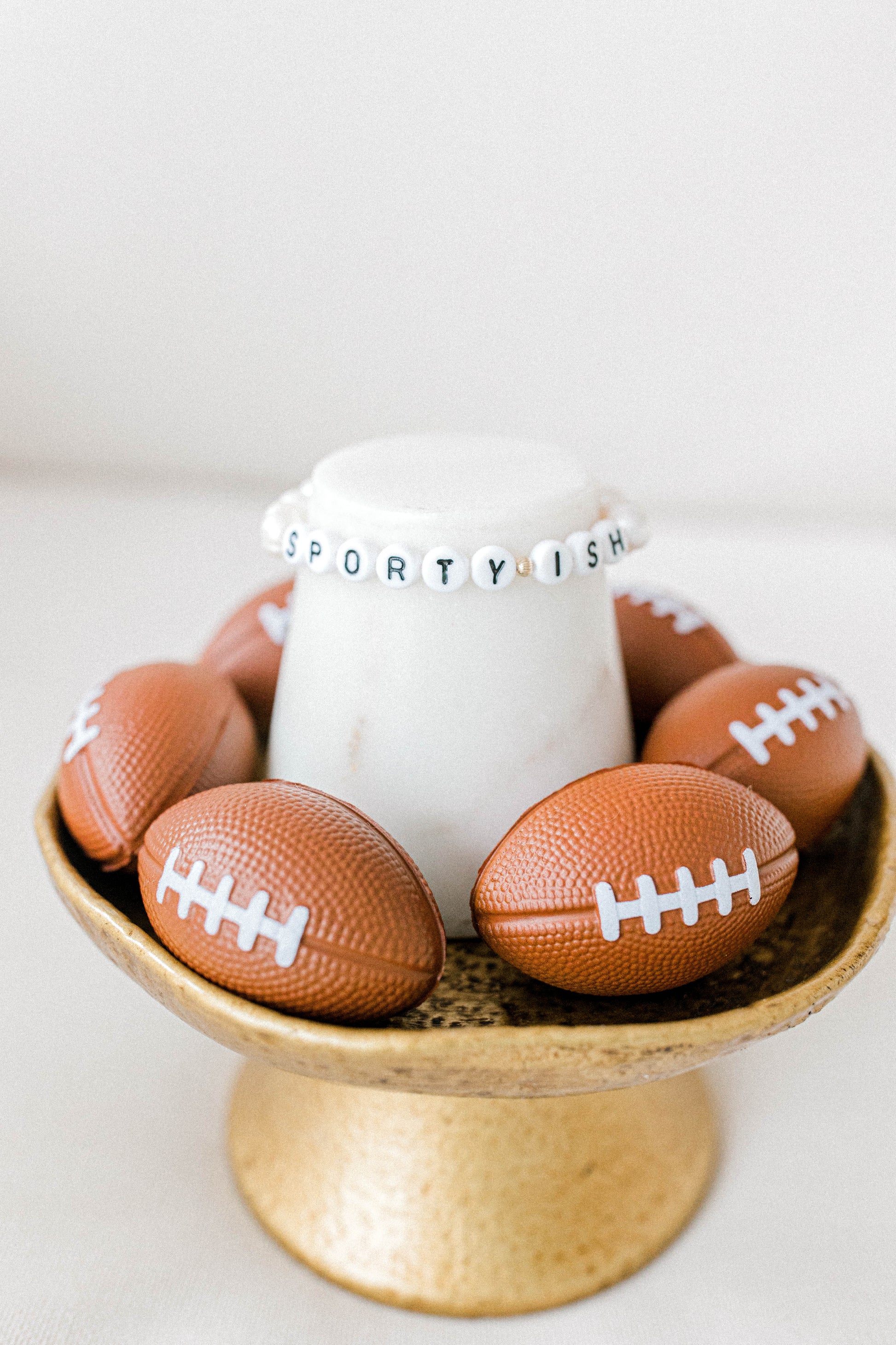 14k gold beaded sporty-ish bracelet with white letter beads posed on a cute football themed display. Handmade using the highest quality materials.